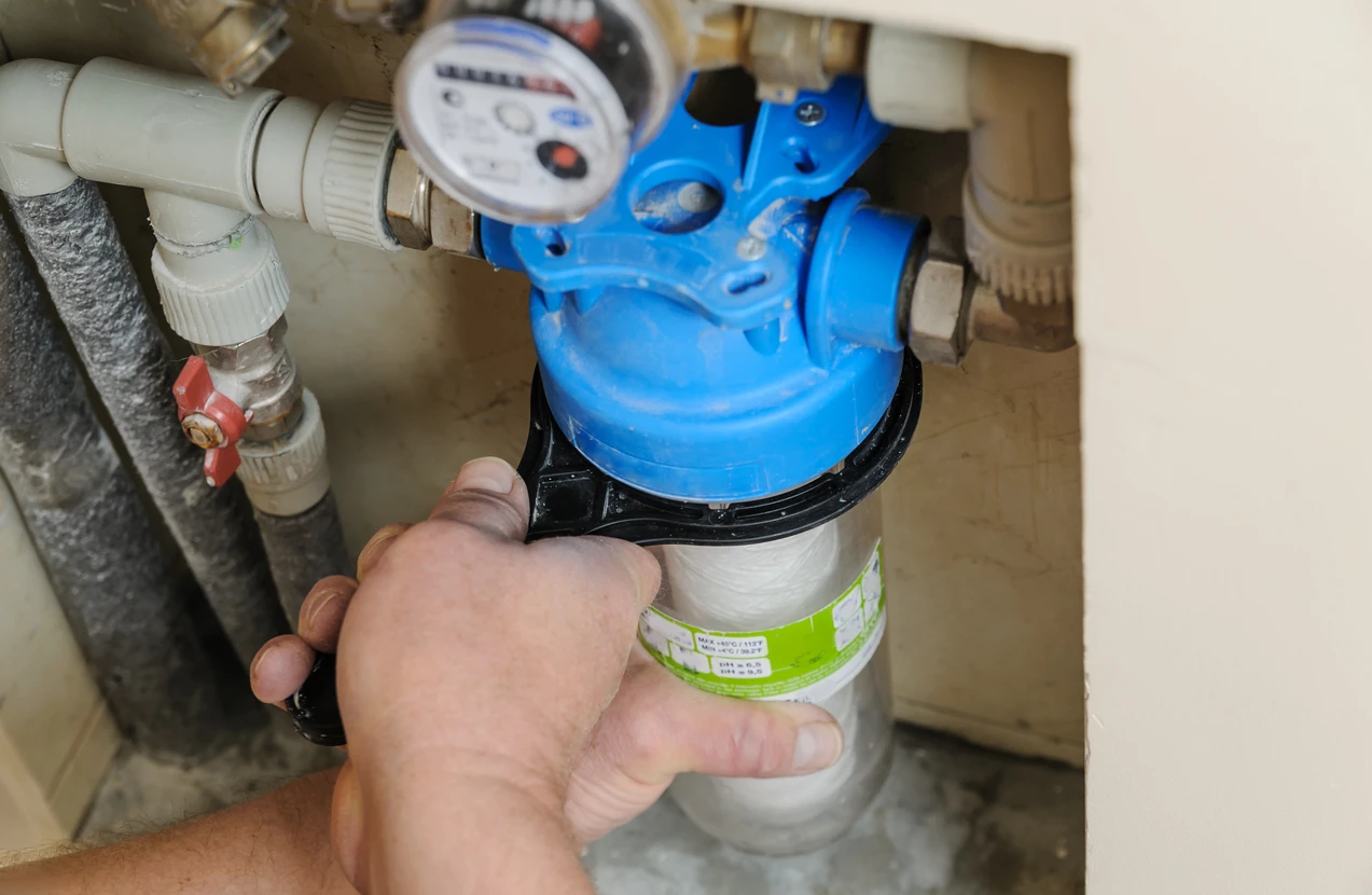 Main courante tenant un système de filtration d'eau domestique avec compteur volumétrique et cartouche filtrante