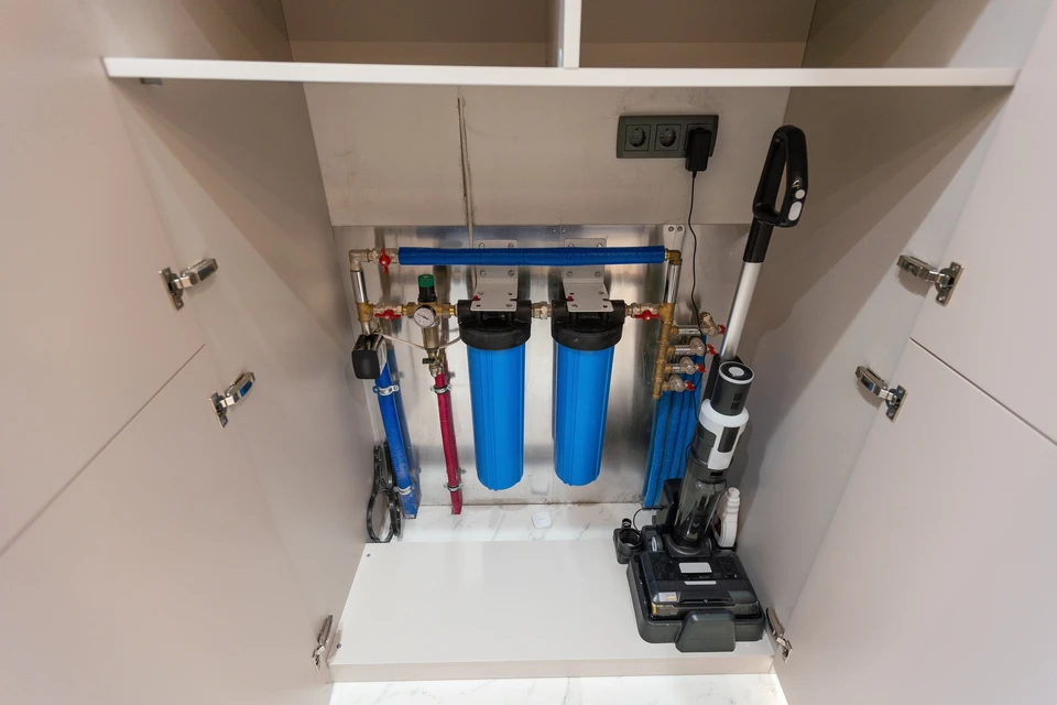 Intérieur d'un meuble sous-évier avec installation de filtration d'eau domestique