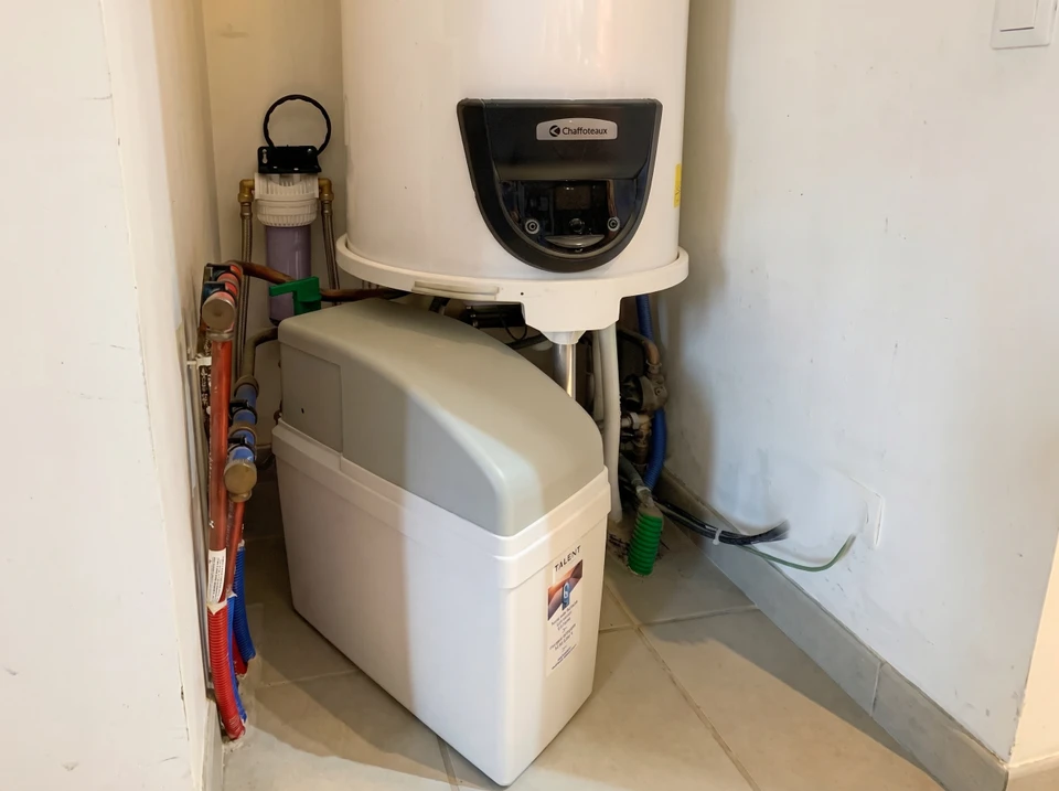 Intérieur carrelé blanc, main masculine manipulant un système de filtration d'eau