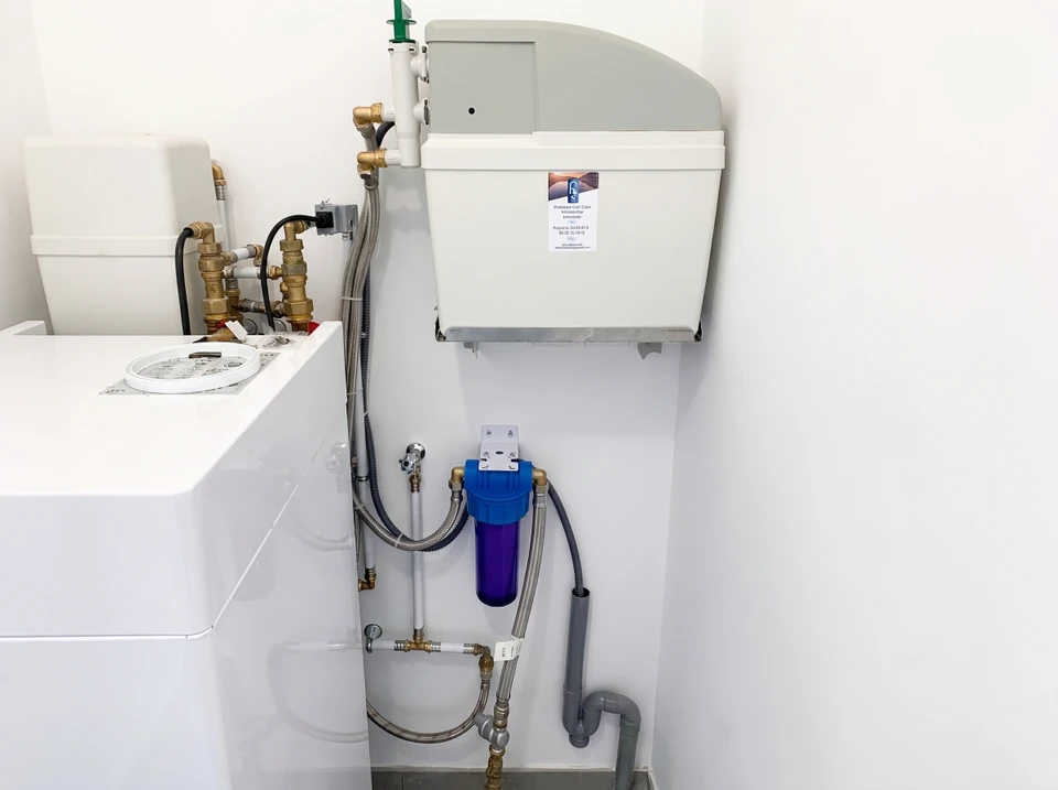 Placard ouvert révélant un système de filtration d'eau domestique installé sous évier